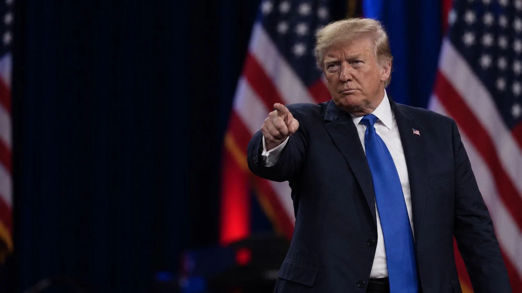 Donald Trump pointe le doigt vers le public lors d’un discours politique aux États-Unis.